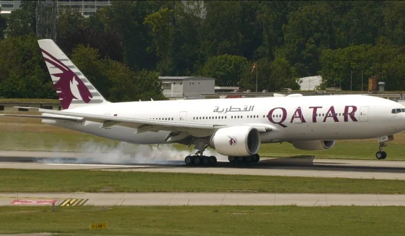 Boeing 777-200LR Qatar Airways касается полосы: короткий фюзеляж, дым из-под шасси, бордовый орикс на киле