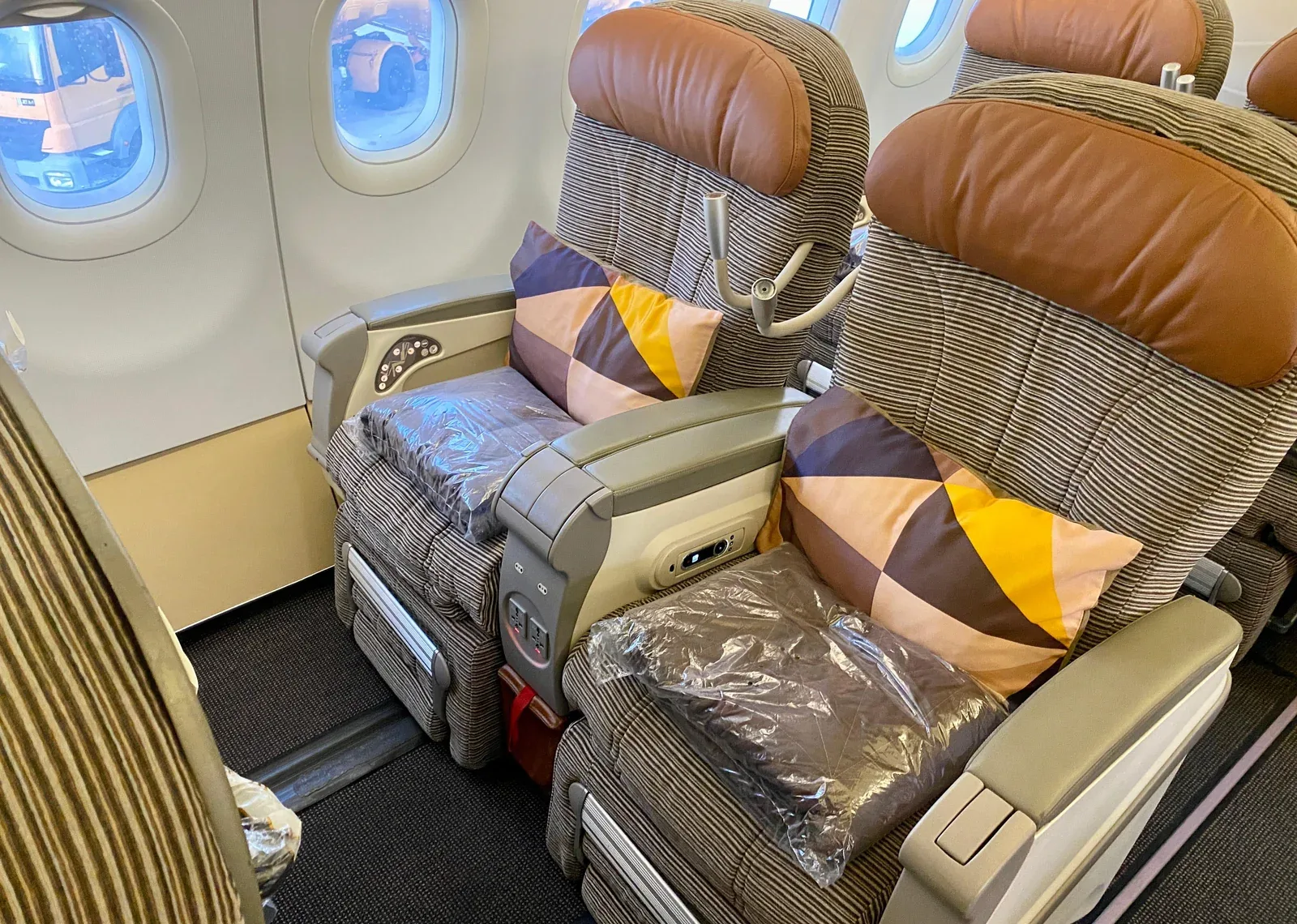 Бизнес-класс Airbus A320 Etihad: кресла парами 2-2 с коричневыми кожаными подголовниками и фирменными подушками