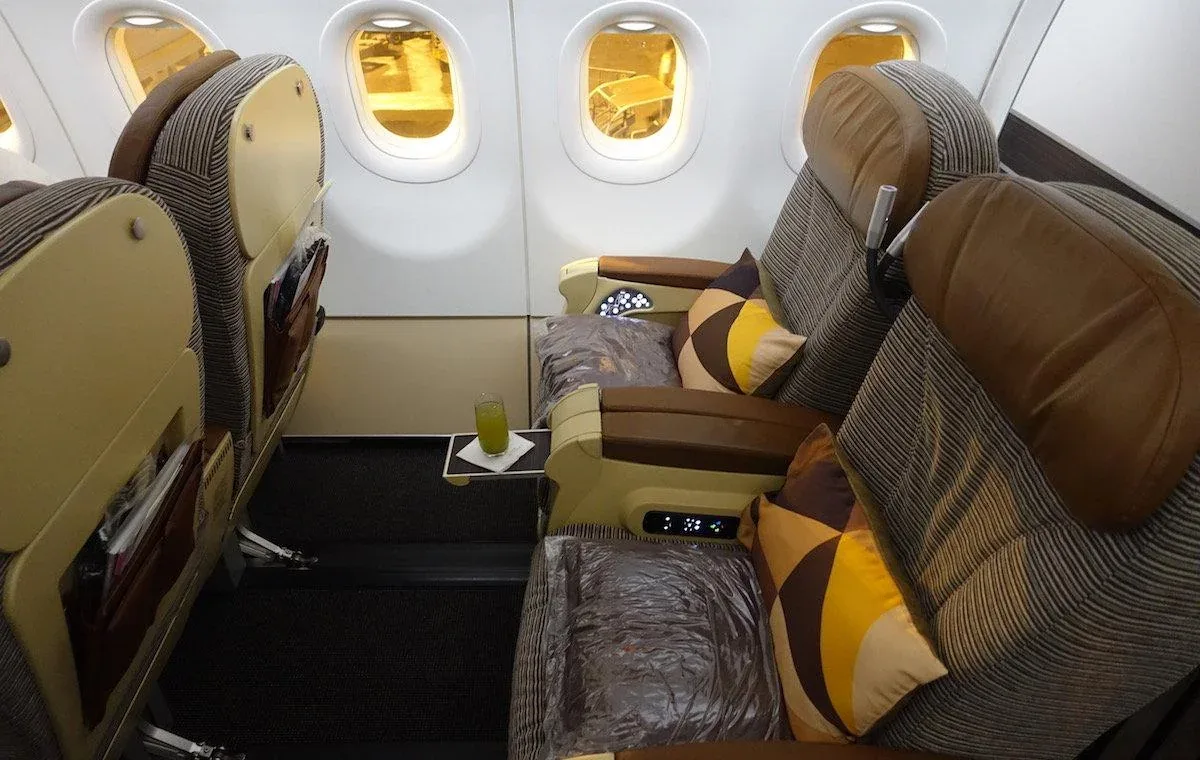 Кресло бизнес-класса Airbus A320 Etihad у окна с откидным столиком и напитком