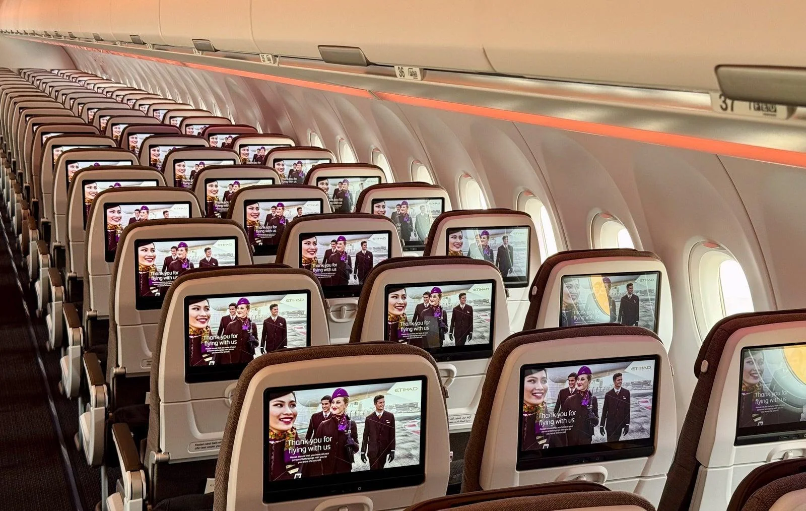 Ряды эконома Airbus A321LR Etihad с включёнными экранами