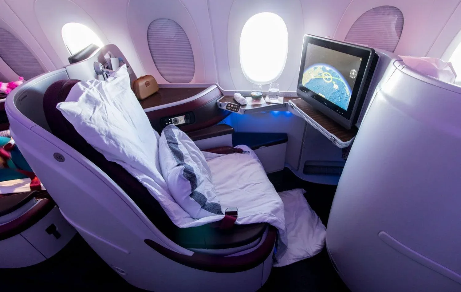 Кресло бизнес-класса Airbus A350-900 Qatar Airways, разложенное для сна, с экраном на стенке впереди