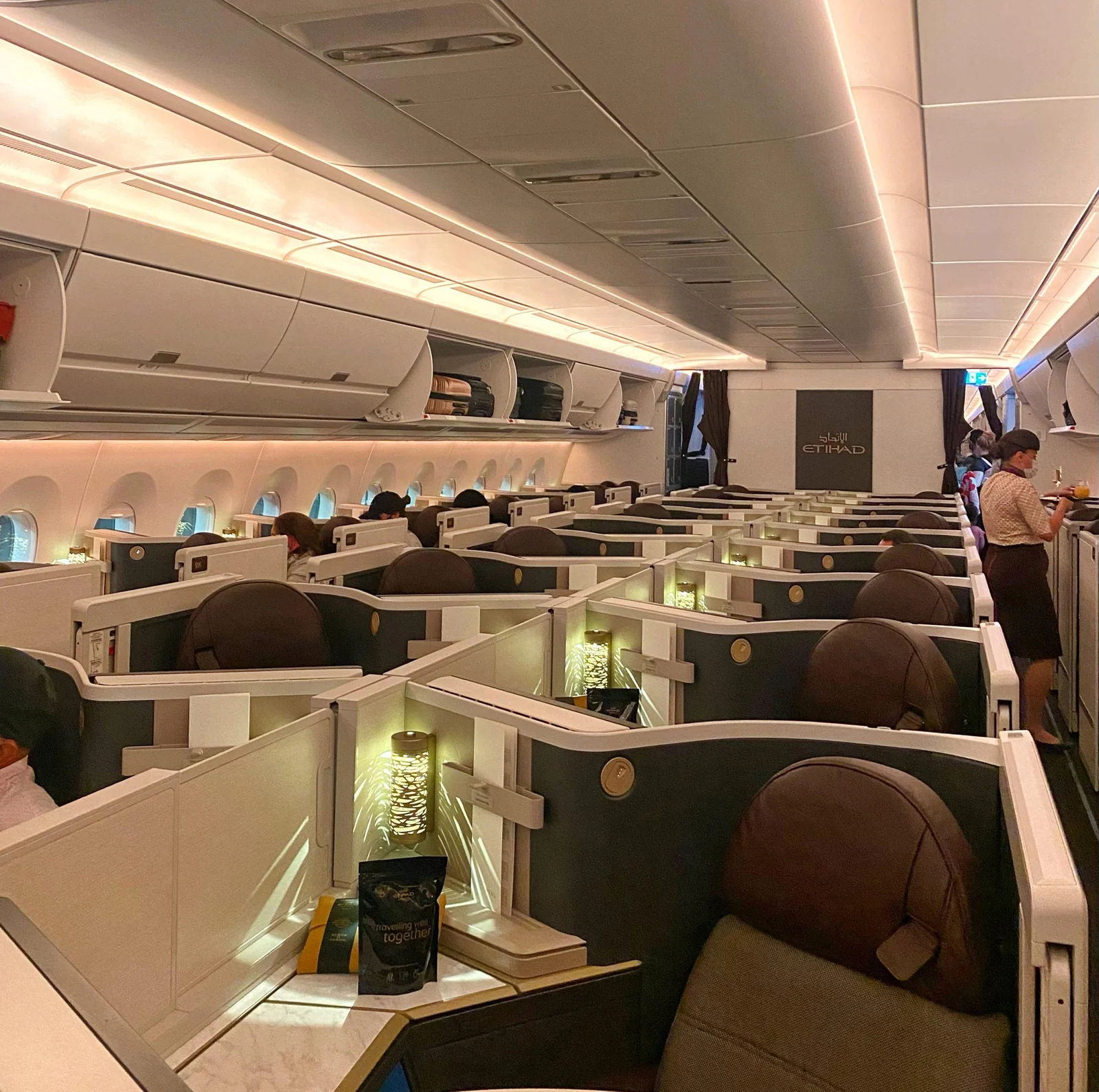 Бизнес-класс Airbus A350 Etihad вечером: перегородки кабин и логотип перевозчика на переборке