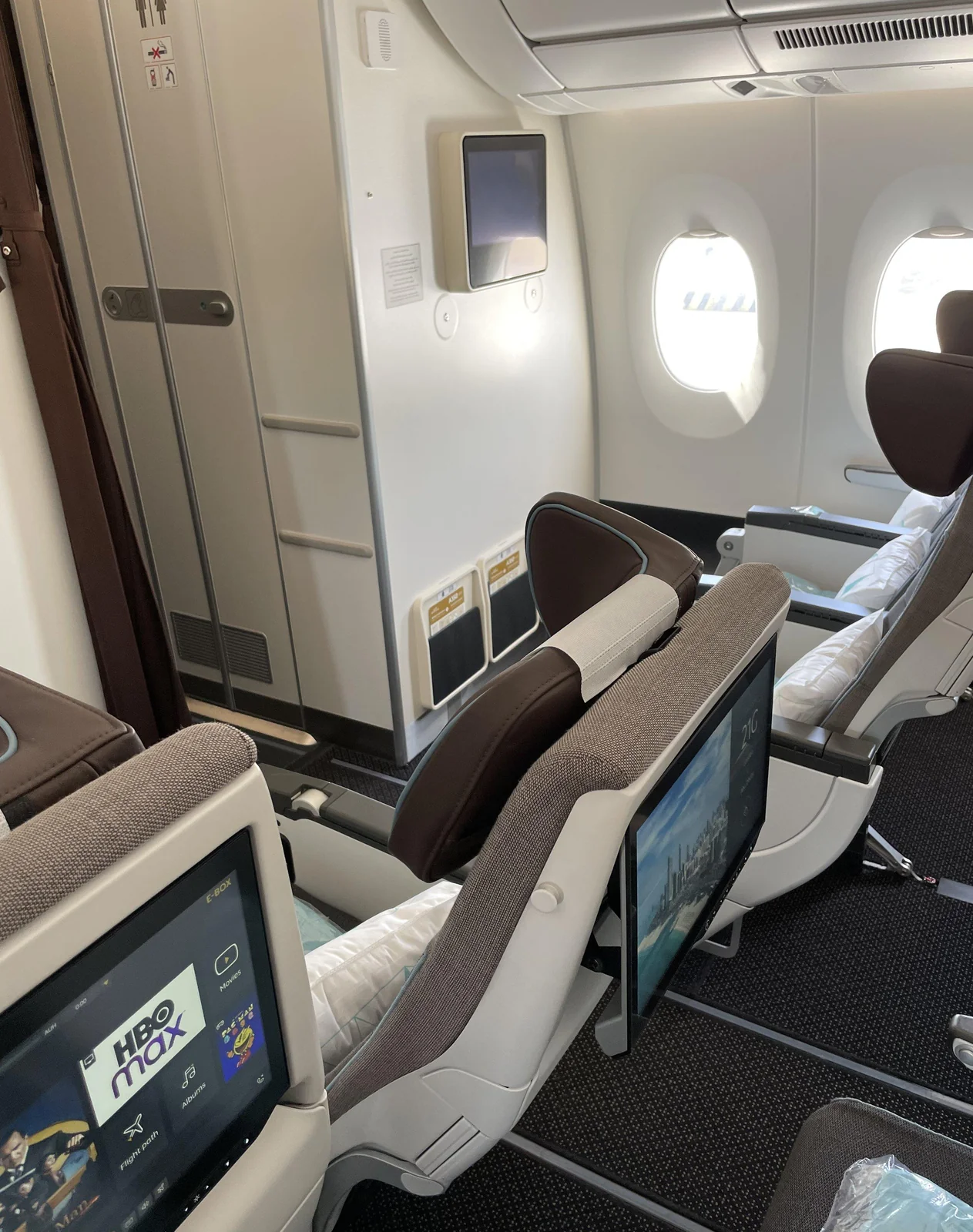 Ряд эконома Airbus A350 Etihad у перегородки: экраны на откидных стойках и окна