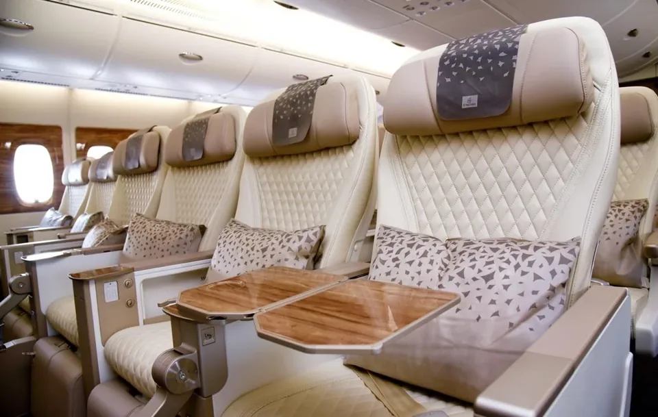 Кресла премиального эконома A380 Emirates с кремовой кожей и откинутыми деревянными столиками