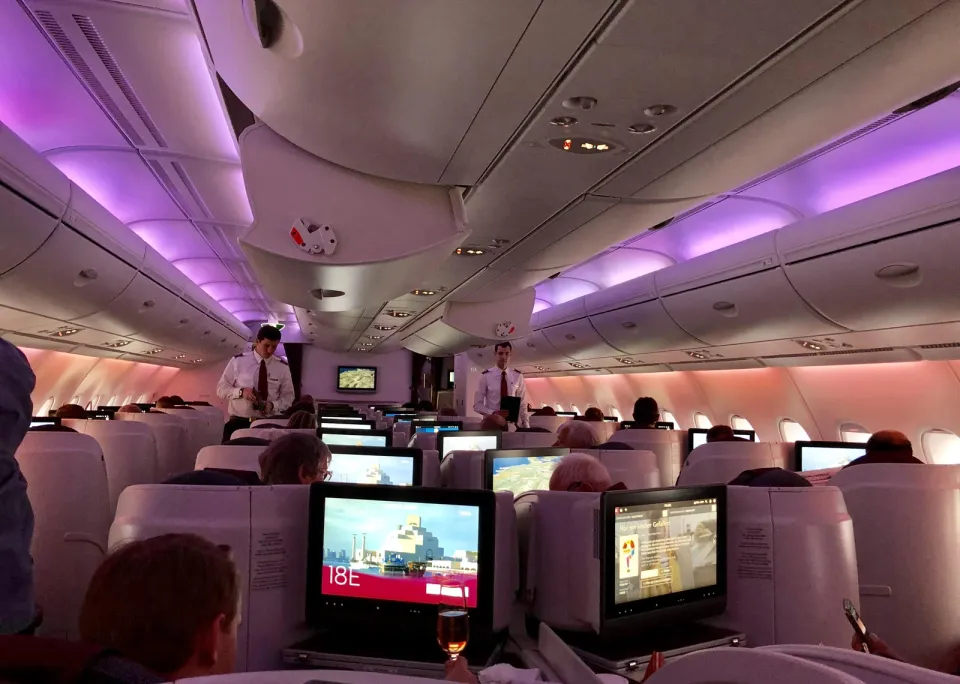 Широкий салон эконома A380 Qatar с экранами, вид вдоль прохода