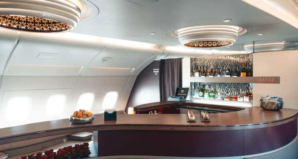Лаунж на верхней палубе A380 Qatar: изогнутая стойка и полки с бутылками