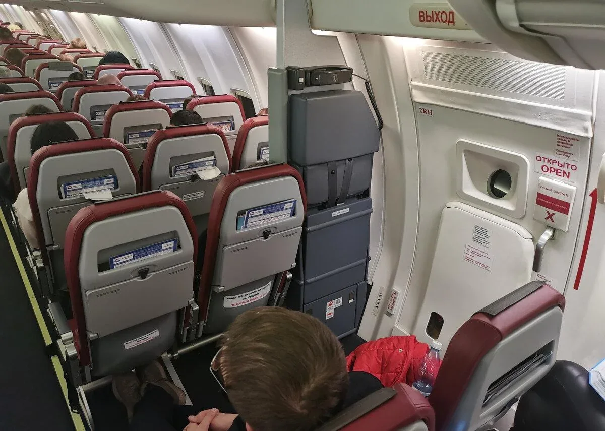 Ряд у аварийного выхода в салоне Boeing 737-900ER «Икара»: дверь 2RH и красно-серые кресла