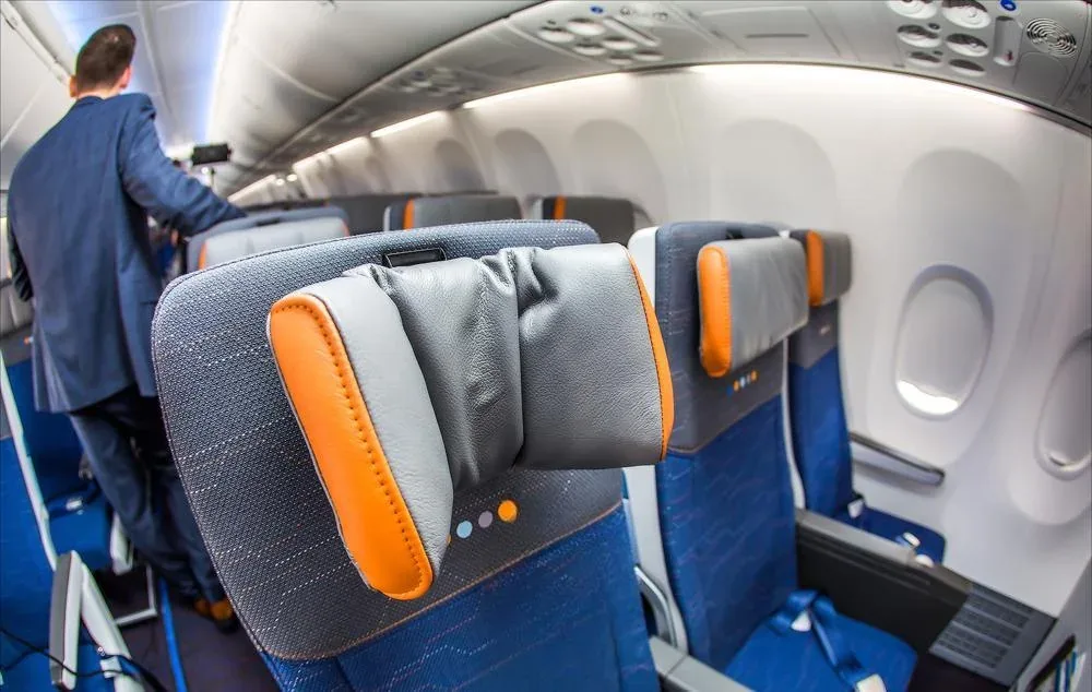 Ряд эконома Boeing 737 MAX 9 flydubai: подголовник с оранжевыми боковинами и полки над креслами