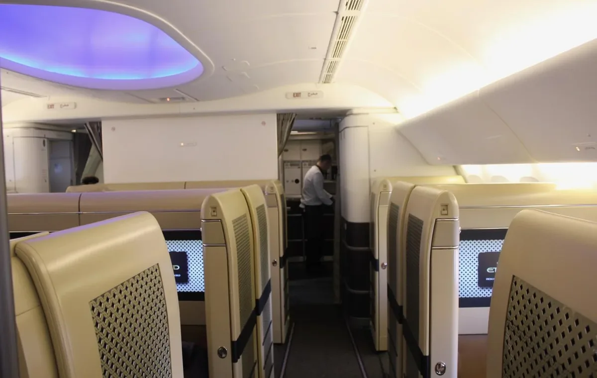 Первый класс Boeing 777-300ER Etihad: закрытые кабины по четыре в ряду, вид вдоль прохода
