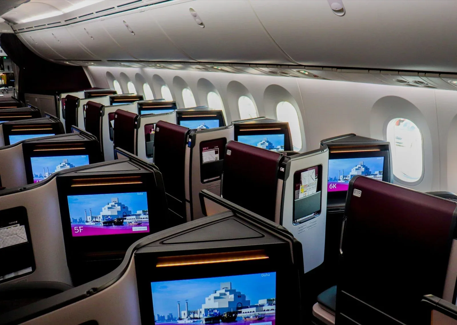 Салон бизнеса Boeing 787-9 Qatar Airways вдоль окон: экраны на стенках кабин