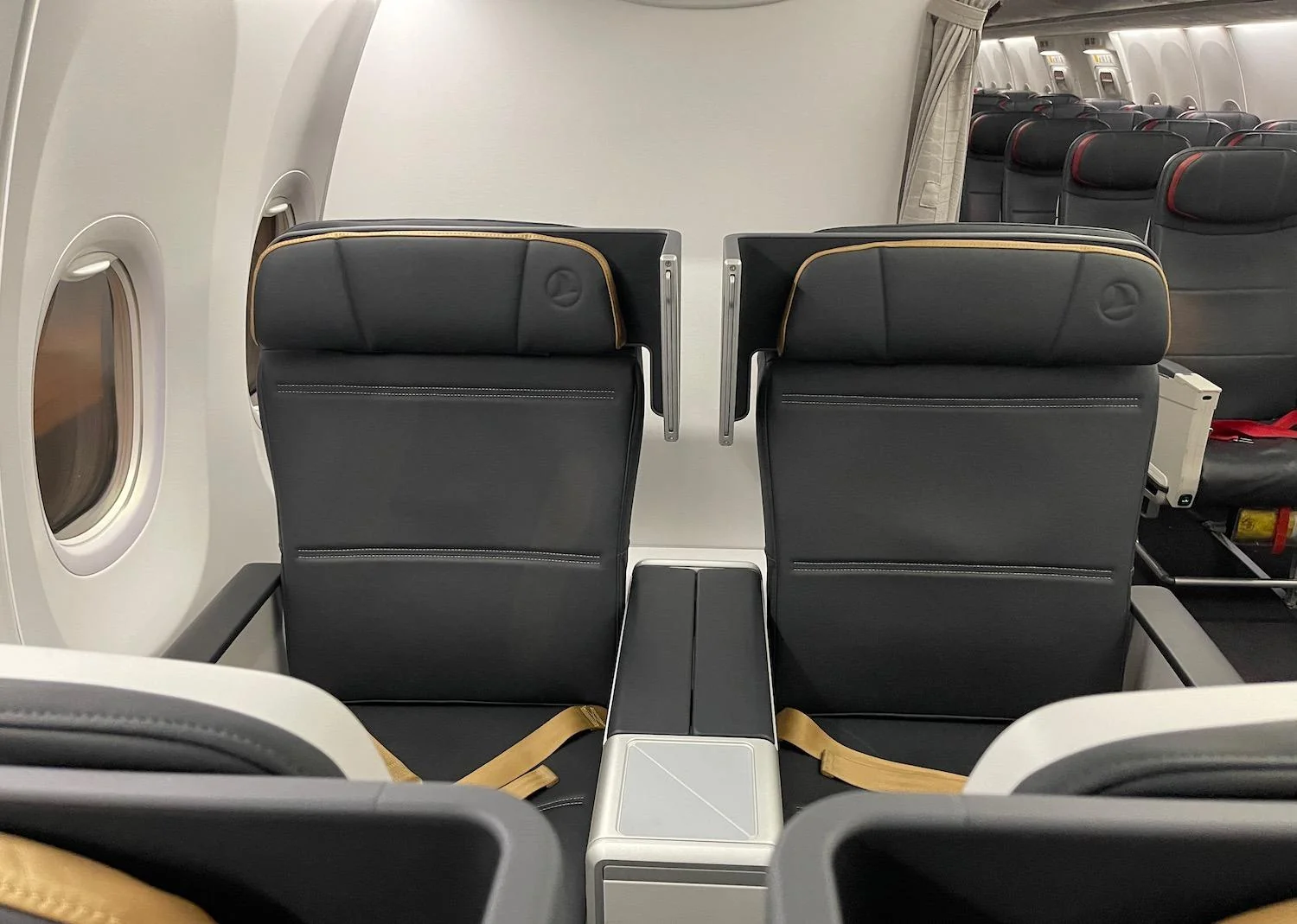 Кресло бизнес-класса Boeing 737 MAX 8 у иллюминатора с откидным столиком