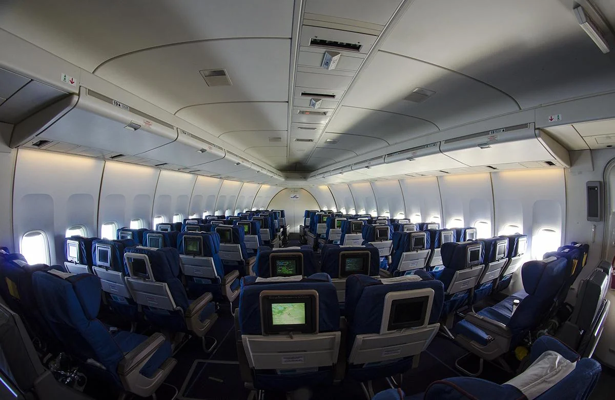 Эконом на верхней палубе Boeing 747-400 «Россия»: синие кресла с экранами под арочным потолком «горба»