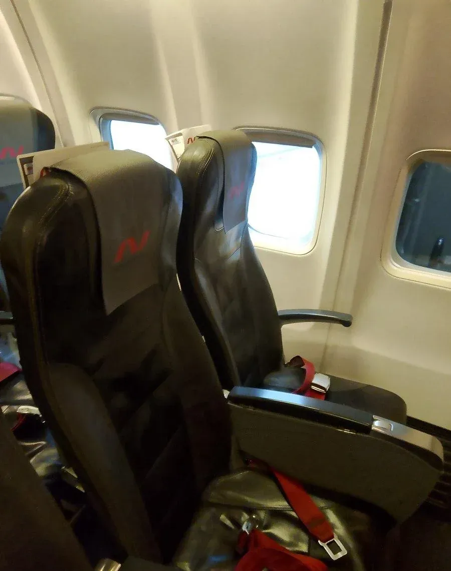 Пара кресел 777-200ER Nordwind у борта с логотипом на подголовнике