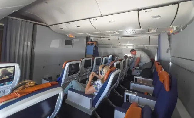 Салон бизнес-класса Boeing 777-300ER Аэрофлот: пары кресел 2-2-2 с оранжевыми подголовниками