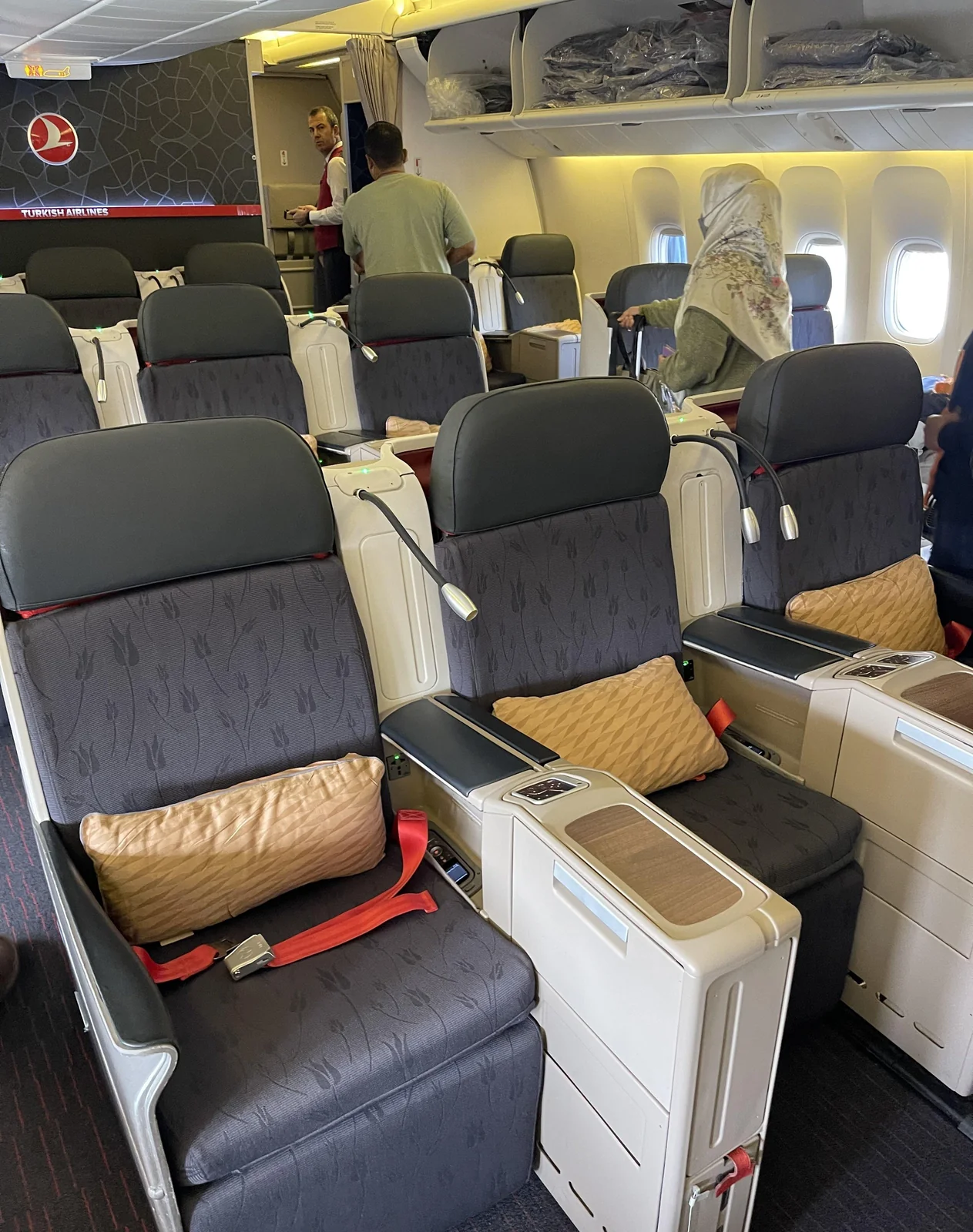 Ряд бизнес-класса Boeing 777-300ER Turkish Airlines с бортпроводником в проходе