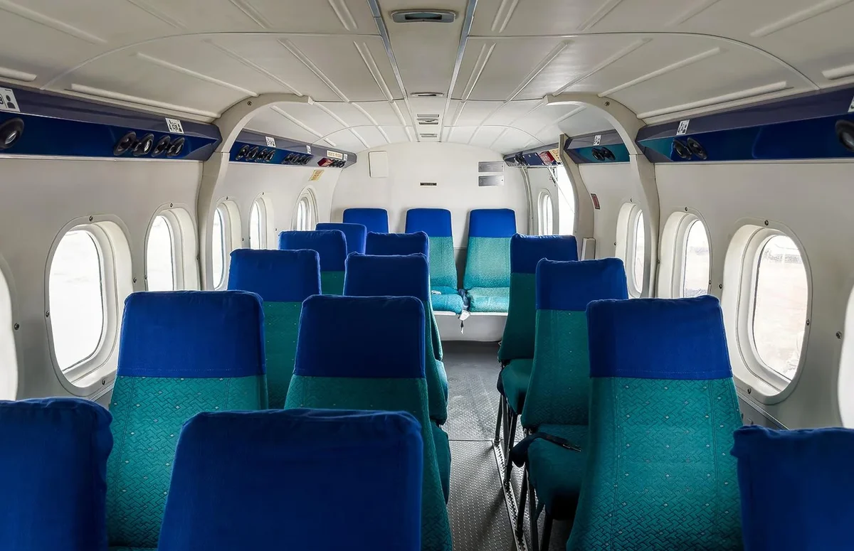 Проход в салоне Twin Otter и таблички EXIT над аварийным выходом