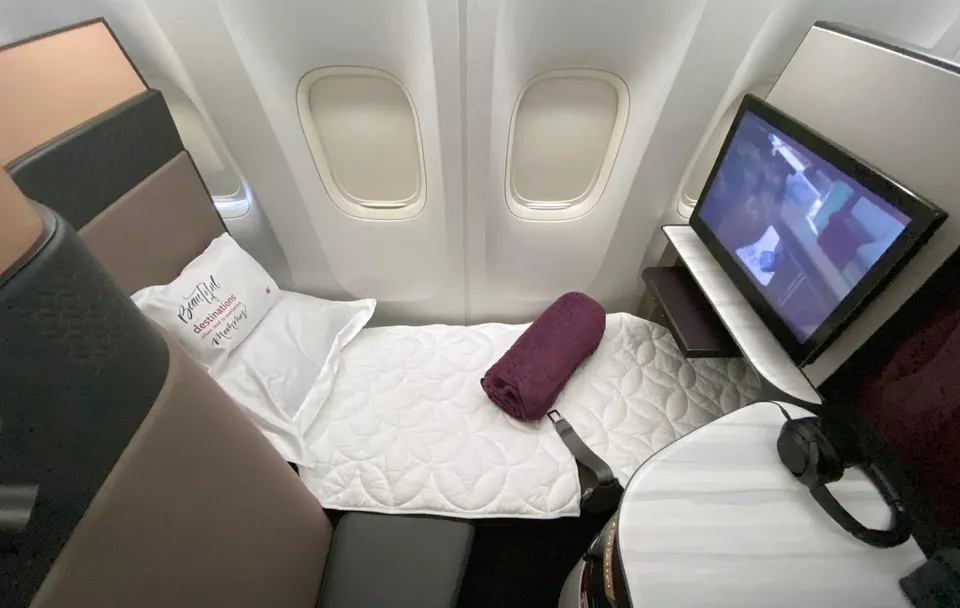 Кресло Qsuite 777-300ER Qatar Airways, разложенное в кровать с матрасом