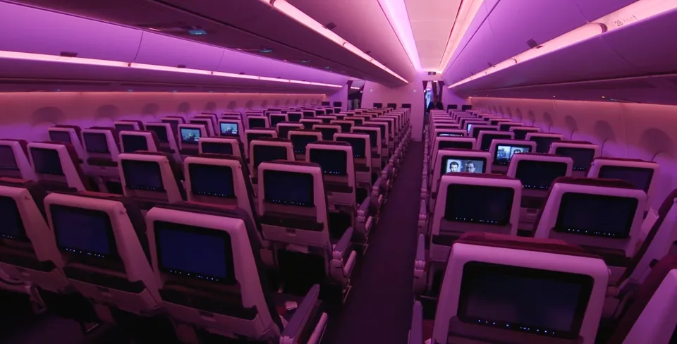 Экраны в спинках кресел эконома A350-1000 Qatar Airways в фиолетовой подсветке