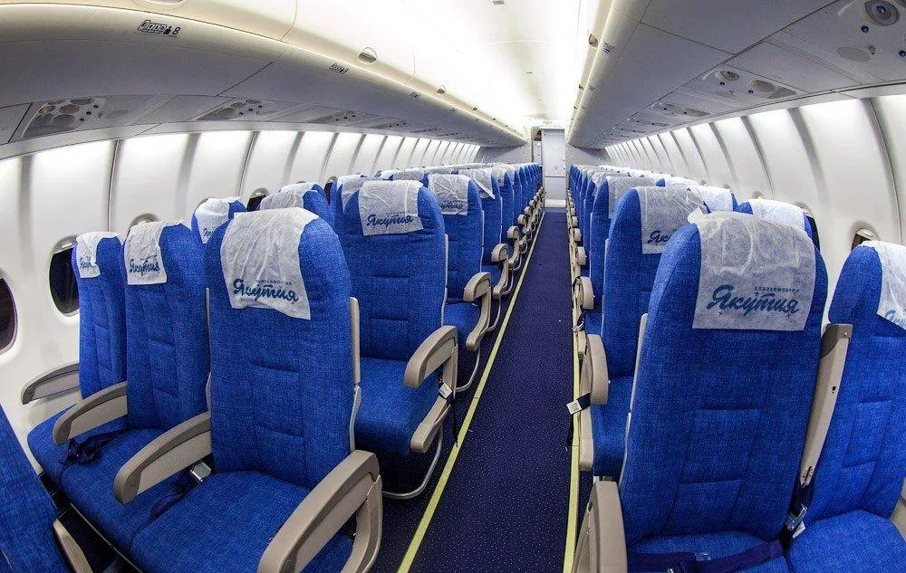 Салон Superjet 100 «Якутии»: синие кресла с чехлами, слева пара мест, справа тройка