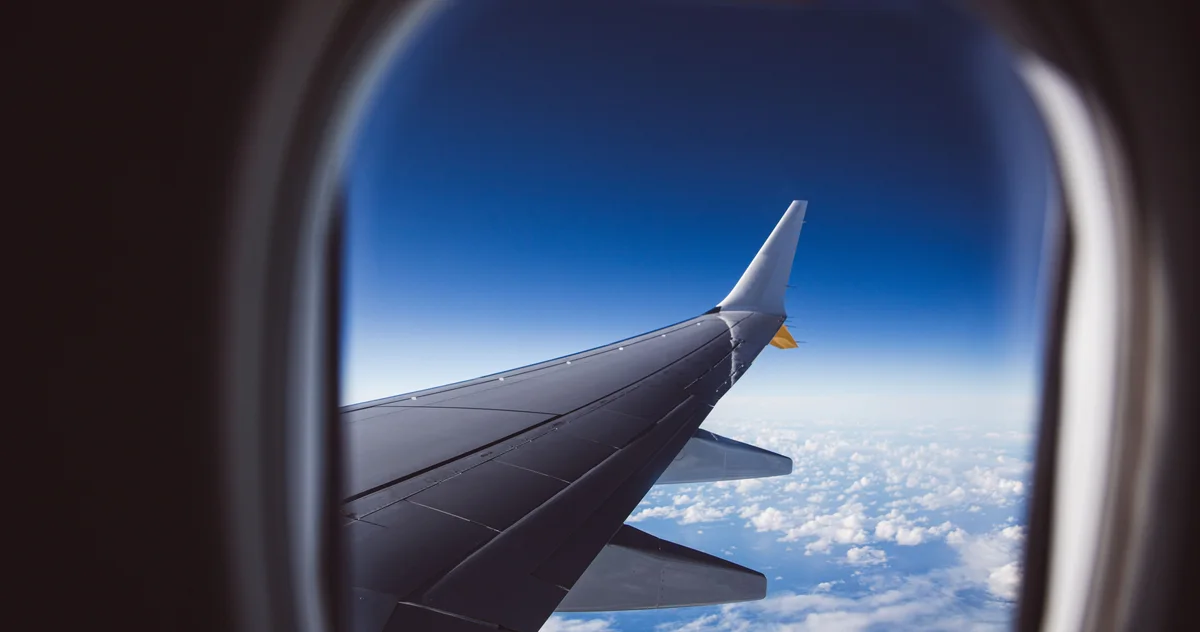 Табличка «Fasten seat belt» на спинке кресла в самолёте